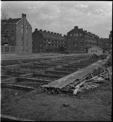 1537 Woningbouw aan de Plantagestraat, in het midden bij de bouwkeet de Vlinderstraat. Geheel op de achtergrond de ...