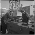 16831 Twee bouwvakkers aan het werk met een buigmachine bij de aanleg van de metro aan het Weena, ter hoogte van de ...