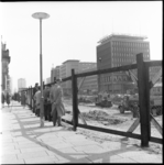 18961 Voor het stadhuis kijken mensen vanachter hekken naar de aanleg van de metro op de Coolsingel. Aan de overzijde ...