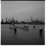 19384 Shell raffinaderij bij Pernis, gezien vanaf de Nieuwe Maas. In het midden van de rivier een schip met de naam 'Heige'.