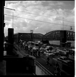 19414 Verkeersdrukte op de Willemsbrug aan de zijde van de Maaskade. Aan de rechterkant is de spoorbrug en een gedeelte ...