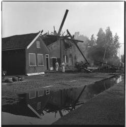 19503 Het nablussen door de brandweer bij de restanten van Molen 'De Ster' aan de Plaszoom in het Kralingse Bos. Twee ...