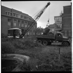 19708 Werkzaamheden voor de bouw van het beddenhuis van het Bergwegziekenhuis aan de Bergselaan. In het gras staan een ...