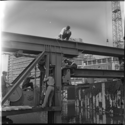 22337 Mannen bezig op een stalen constructie bij de aanleg van de metro op het Weena, ter hoogte van het Hilton Hotel. ...
