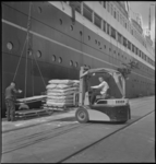 2260 Twee mannen laden met een vorkheftruck goederen in bij een passagiersschip van de HAL aan de Wilhelminakade.