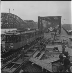 23020 Werkzaamheden aan de tramrails tijdens de bouw van de Verlengde Willemsbrug. Een volle tram van lijn 3 rijd nog ...