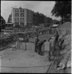 25831 Werklieden aan het werk voor de bouw van het metrostation Maashaven aan de Brielselaan. Links de Mijnsherenlaan.