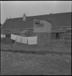 3139 De achterzijde van woningen aan de IJsselmondselaan nrs 96-104 met opgehangen wasgoed.