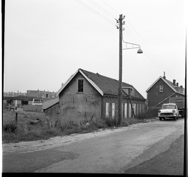 36798 Zicht op enkele woningen aan de Buitendijk in Groot IJsselmonde, met op de achtergrond links een autobedrijf.