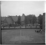 36934 Zicht op het schoolgebouw aan de Ploegstraat, met op de voorgrond het schoolplein waar meerdere leerlingen met ...