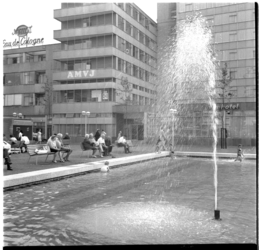 41440 Publiek op bankjes bij de fontein op het Schouwburgplein. Op de achtergrond het Rijnhotel.