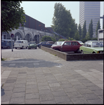 70899 De Raampoortstraat met geparkeerde auto's en bedrijfspanden, waaronder een glashandel, in de hofbogen.
