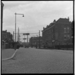 7277 Zicht op de Rose-Spoorstraat met enkele woningen, vanaf de Rosestraat. Op de achtergrond rijdt de tram.