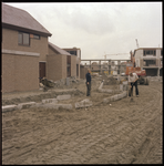 74006 Zicht op de wijk Oosterflank in aanbouw. Op de voorgrond twee mannen bezig met de aanleg van de stoep.