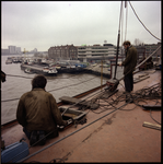 74809 Zicht op werkzaamheden voor de bouw van de Willemsbrug aan de zijde van de Maaskade. Verderop de Nieuwe Maas met ...