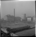 7686 Overzicht op het terrein voor het latere Plein 1940 bij de Leuvensluis. Op de achtergrond het warenhuis De Bijenkorf.
