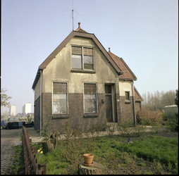 76910 Zicht op een vervallen woning aan de Capelseweg 95, met op de achtergrond enkele flatgebouwen.