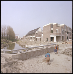 76951 Zicht op de in aanbouw zijnde wijk Beverwaard. Op de voorgrond spelende kinderen in het zand.