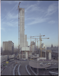 86325 Zicht op werkzaamheden voor de bouw van het kantoorgebouw de Delftsepoort aan het Stationsplein. Op de voorgrond ...