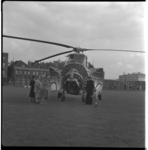 8831 Wachtende mensen bij een helikopter met een opengeklapte voorkant. Bij de Heliport aan de Katshoek, op de ...