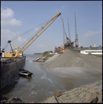 93833 Werkzaamheden voor het dempen van de Vliethaven, ter hoogte van de Nieuwe Maas. Links ligt een schip waar zand ...