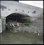 94820 Aangespoeld afval en losse stenen in het water en onder de kademuren van het Vrij Entrepot aan de Entrepothaven.