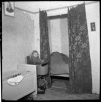AO-154 Zicht op een slaapkamer van een rug-aan-rugwoning in de Hendrikstraat. Een klein kind zit in de kinderstoel. ...