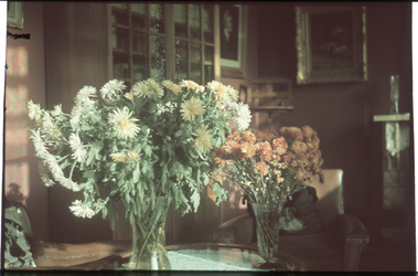 84 Het interieur van de woonkamer met vazen bloemen van de familie Boske.