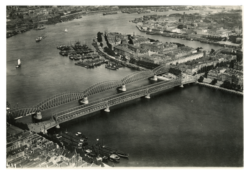 1970-1859 Luchtopname ter hoogte van de Nieuwe Maas met in het midden de twee bruggen (Spoorbrug en Willemsbrug), ...