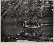 1970-572 Luchtopname van de omgeving van de Middenkous (vooraan) en de Achterhaven (rechts), waar veel schepen liggen. ...