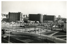 1977-686 Zicht op het parkeerterrein tussen de Karel Doormanstraat en het Kruisplein, met op de voorgrond een deel van ...