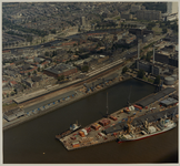 1987-2235 Luchtopname van de Schiehaven, en vooraan enkele schepen aan de kade. Verderop een gedeelte van de wijk ...