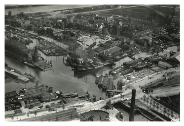 VII-380-01 Luchtopname van schepen in de haven bij de Middenkous, met links de Voorhaven en Achterhaven met in het ...
