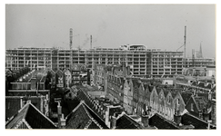 XIV-398-17 Zicht op het Groothandelsgebouw in aanbouw, met rechts de bouw van het Centraal station, vanaf woningen aan ...