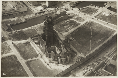XVIII-128-00-30 Luchtopname van het Grotekerkplein met de zwaar beschadigde Sint-Laurenskerk in de steigers, en op de ...