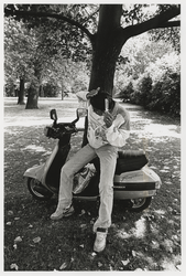 2002-1021 Een jongen kamt zijn haren voor de spiegel van zijn scooter in het Park.
