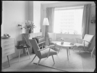 L-1175 Interieur van een flatwoning aan de Van Adrichemweg in Overschie. In de kamer staan stoelen, een tafel, een ...