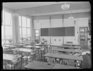 L-1549 Klaslokaal met tafels, stoelen en schoolbord in de Zuiderparkschool voor GLO (Gewoon Lager Onderwijs) aan de ...