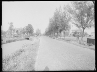 L-1563 's-Gravenweg, een landweg langs boerderijen. Links een sloot, rechts een rij bomen.