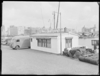 L-1816 Walhuisje aan de Leuvehaven. Aan de kade liggen tonnen. Op het dak staat een bord met de tekst 'N.V. Reederij ...