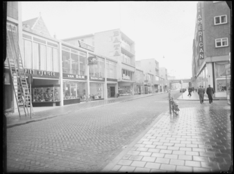 L-1821 Winkels in de Hoogstraat, op de achtergrond het spoorviaduct. Links de winkels Piet Heniger, Van Dam ...