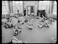 L-1927 Gymnastiekles op kleuterschool Ontluikend Leren aan de Duyvesteynstraat 31 in Overschie. Op de achtergrond een ...