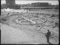 L-1971 Man kijkt naar het fundament voor Nationaal Koopvaardijmonument De Boeg. Op de achtergrond de Leuvehaven met ...