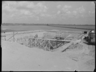 L-1973 Bouwvakkers storten beton bij de bouw van de fundering voor gemaal Breeman bij de Koedood. Rechts een betonwagen.