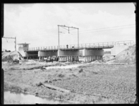 L-201 Bouwvakkers werken aan de bouw van een spoorwegviaduct over de Van Aerssenlaan. Onder het viaduct lossen mannen ...