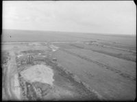 L-2098 Luchtfoto van werkzaamheden bij de aanleg van vliegveld Zestienhoven. Links op de voorgrond een zandhoop met ...
