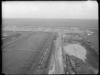 L-2100 Luchtfoto van werkzaamheden bij de aanleg van vliegveld Zestienhoven. Rechts op de voorgrond een zandhoop met ...
