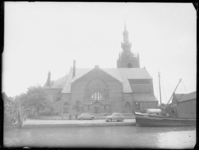 L-2196 De Grote kerk in Overschie. Op de voorgrond ligt het binnenvaartschip Adrianan in de Delftse Schie.