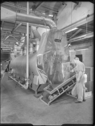 L-2629 Man bedient een machine in tabakfabriek J & A.C. van Rossem aan de Boezemsingel.