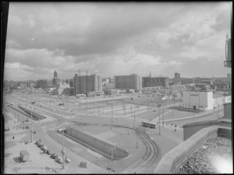L-2677 Overzicht over het Stationsplein. Op de voorgrond van links naar rechts het Weena met tunnel. Op de achtergrond ...